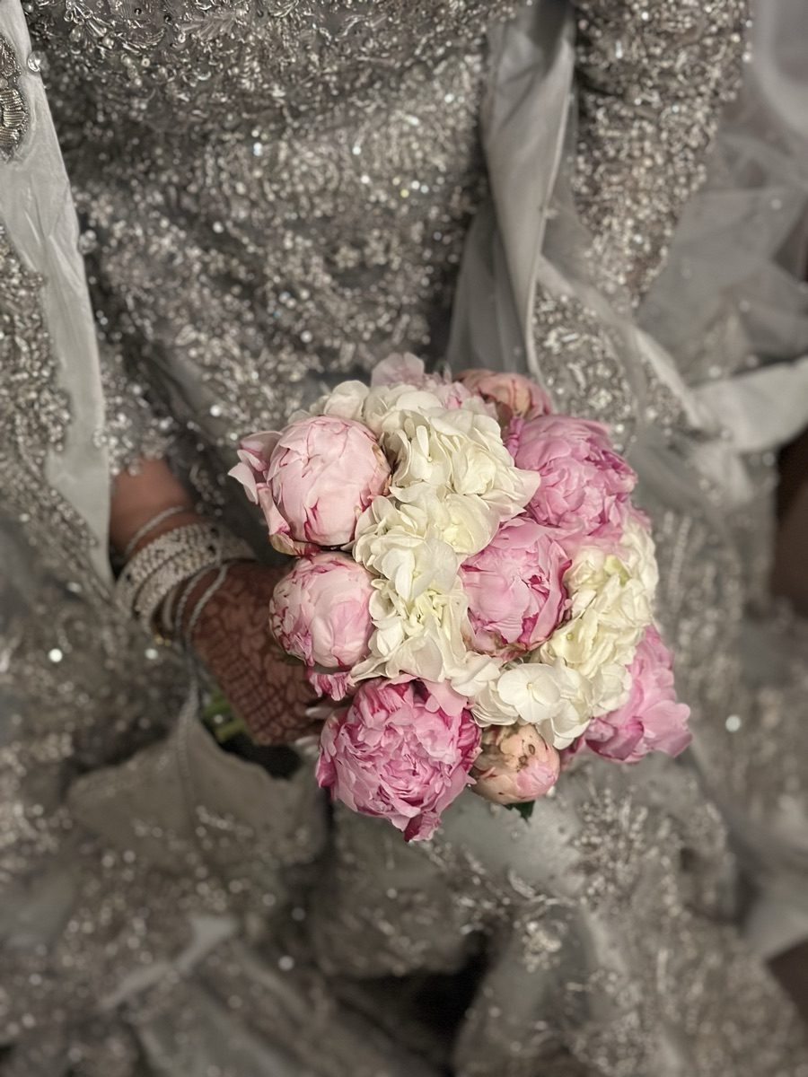 Bride in embellished gown with henna holding a pink peony and white hydrangea bridal bouquet